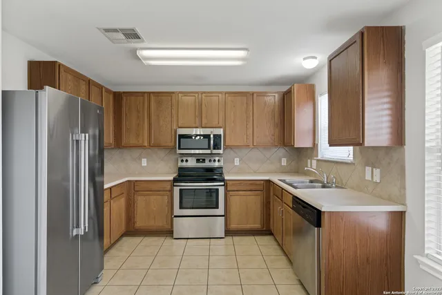 a kitchen with a sink a refrigerator and cabinets