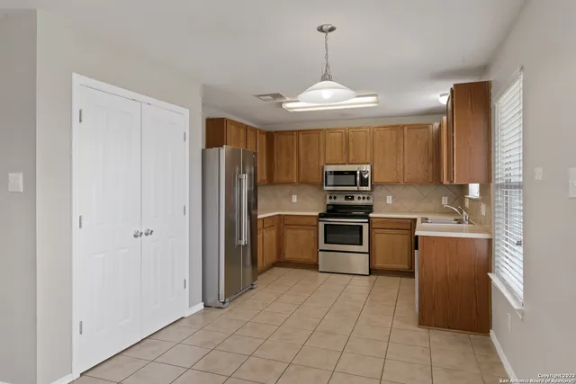 a kitchen with stainless steel appliances granite countertop a refrigerator and a stove top oven