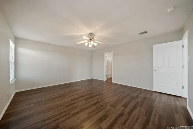 a view of an empty room with wooden floor