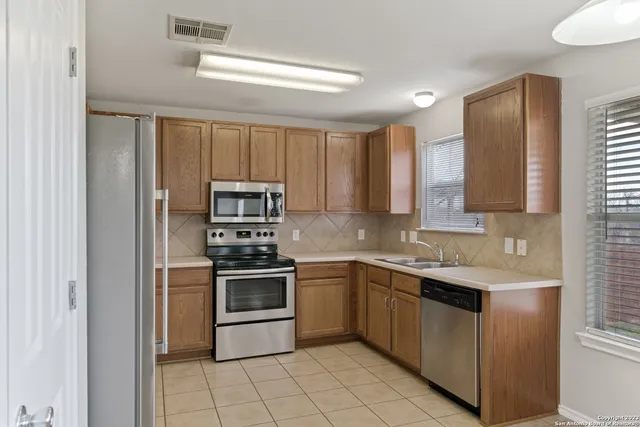 a kitchen with stainless steel appliances granite countertop a stove top oven and sink
