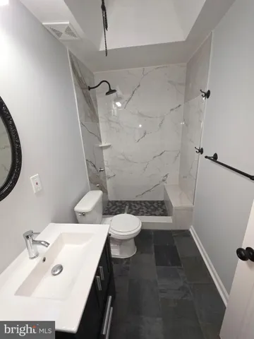 a bathroom with a sink a toilet and a mirror