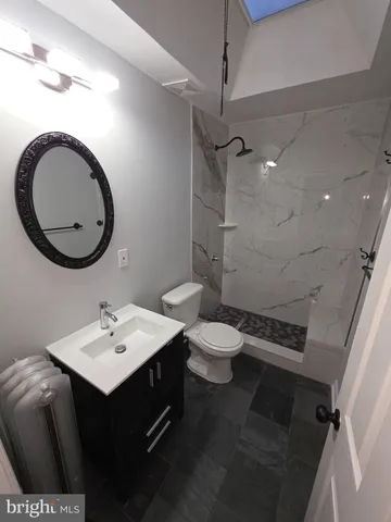 a bathroom with a sink a toilet and a mirror