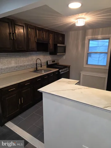 a kitchen with a sink a stove and cabinets