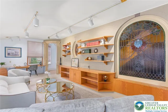 a view of a livingroom with furniture a chandelier fan and wooden floor