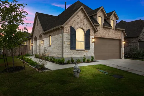 a front view of a house with a garden and plants