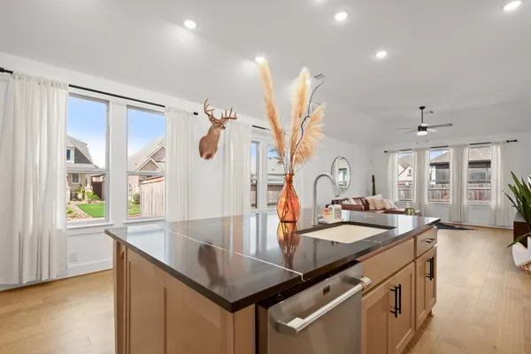 a kitchen with stainless steel appliances granite countertop a sink a stove and a refrigerator