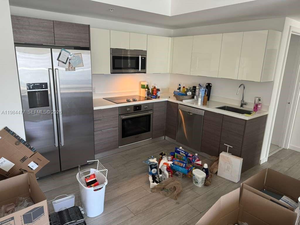 1010 Southwest 2nd Avenue, Unit 1502 Miami, FL 33130 - Photo 6 of 19 a kitchen with a refrigerator and a sink