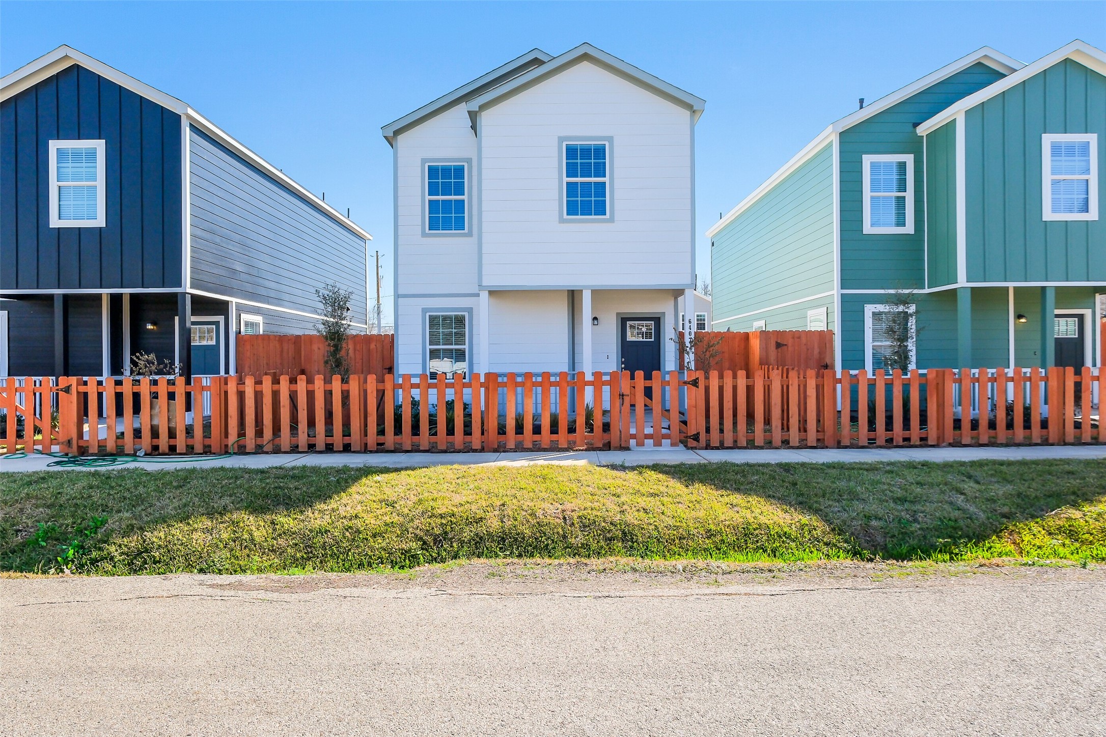 a view of a house with a yard and fence