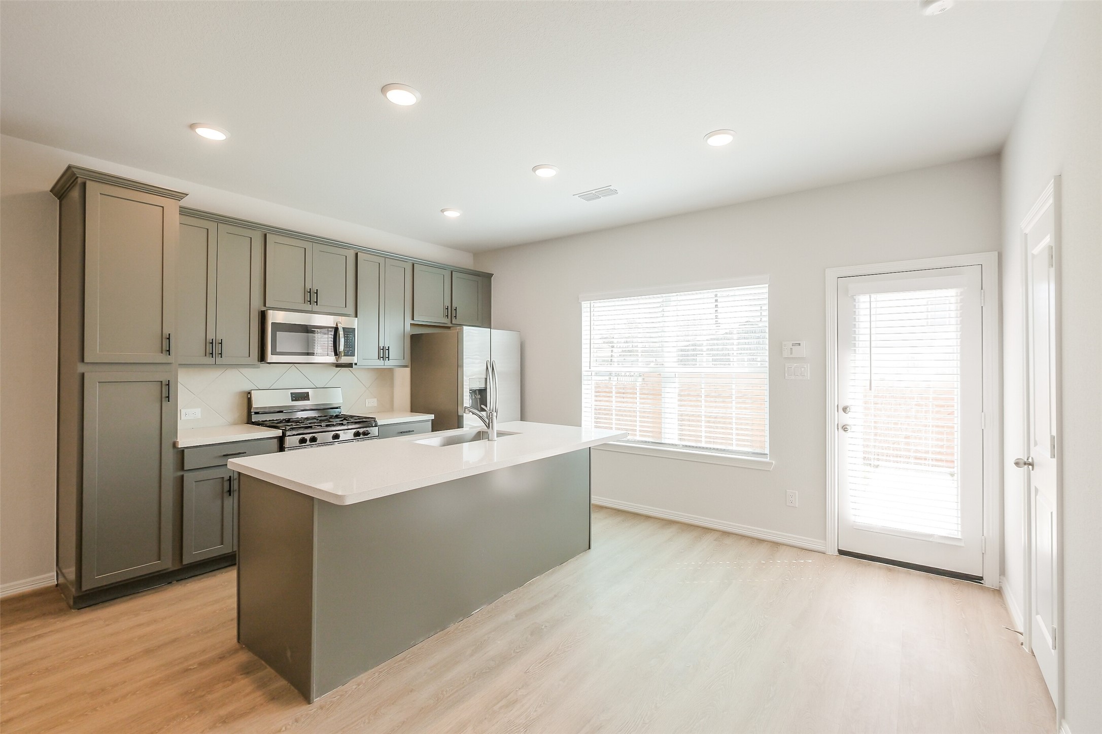 6411 Paris Street Houston, TX 77021 - Photo 12 of 33 a kitchen with stainless steel appliances a refrigerator a stove a sink and white cabinets