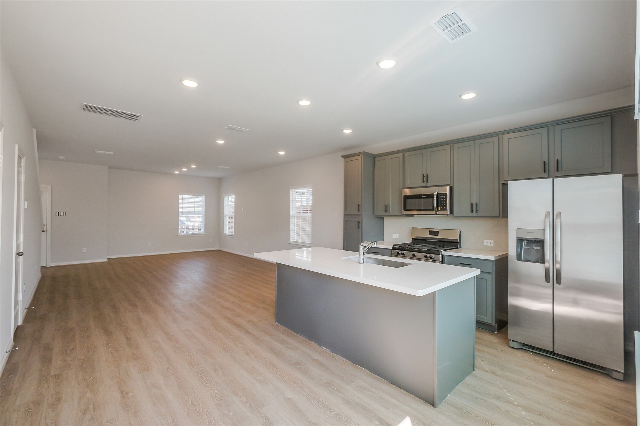 6411 Paris Street Houston, TX 77021 - Photo 13 of 33 a kitchen with stainless steel appliances a stove a sink a refrigerator white cabinets and wooden floor
