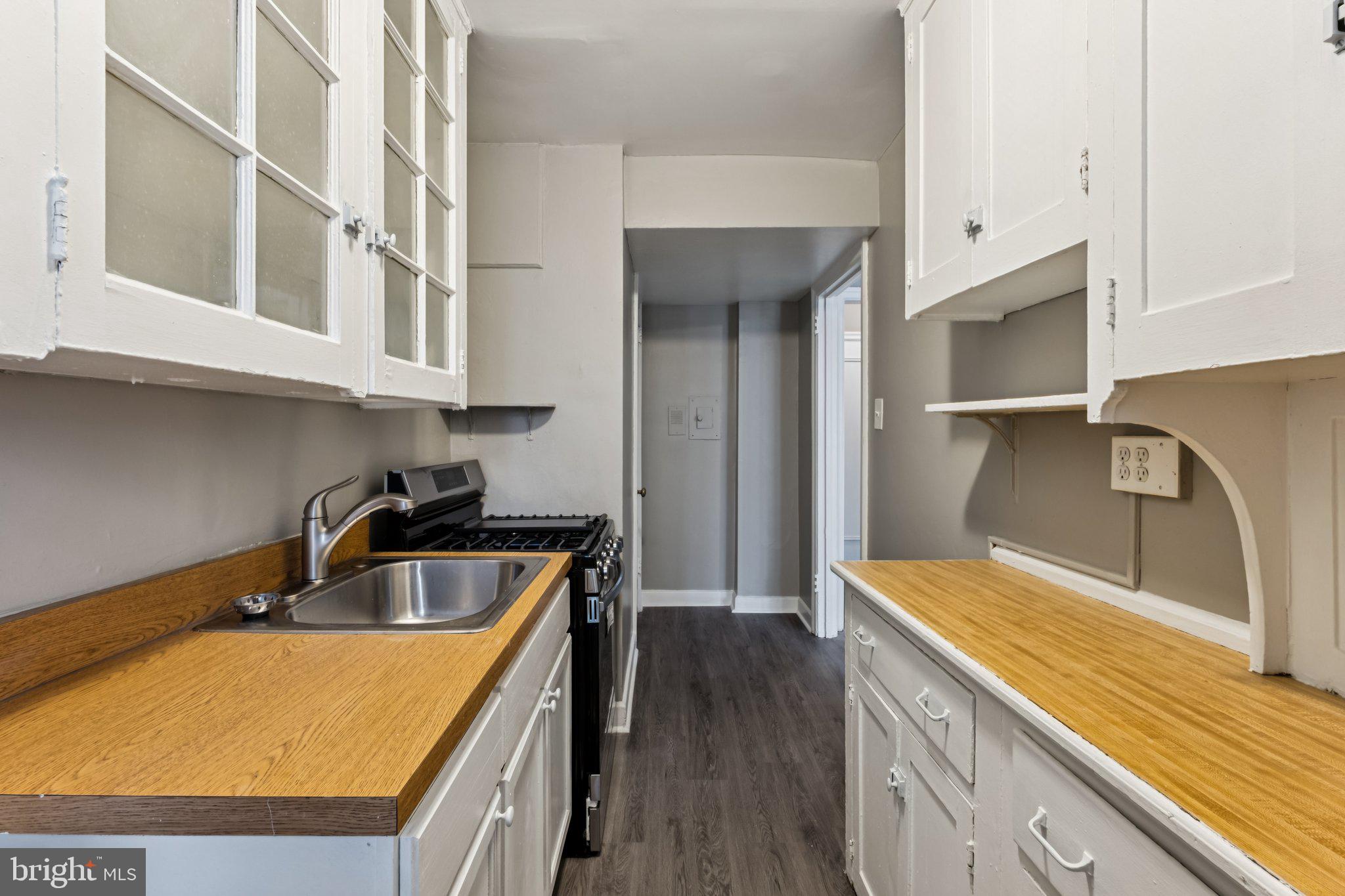 2031 Locust Street, Unit 504 Philadelphia, PA 19103 - Photo 6 of 14 a kitchen with stainless steel appliances granite countertop a sink and wooden cabinets