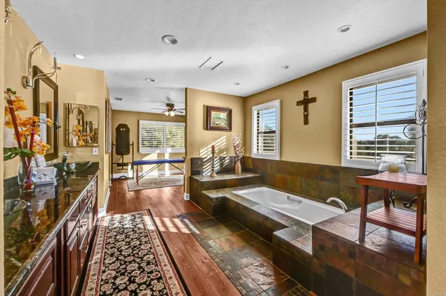 a view of a room with wooden floor and a ceiling fan