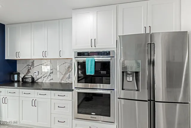 a kitchen with cabinets and stainless steel appliances