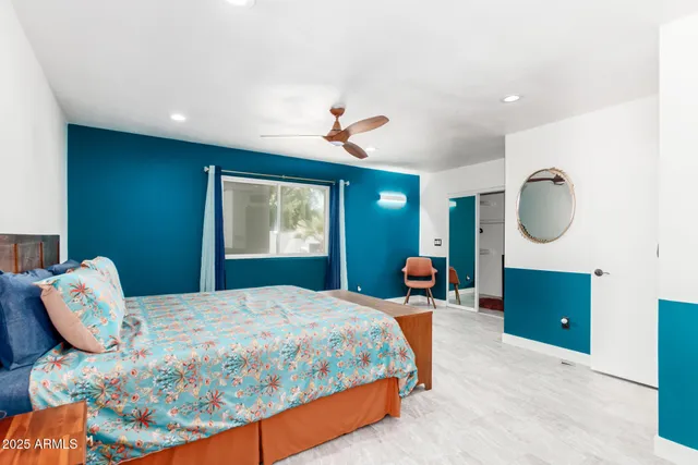 a bedroom with a bed and dresser with mirror