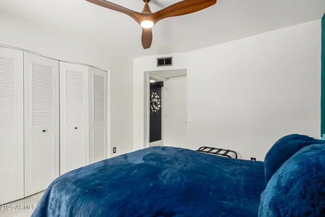 a bedroom with a bed and a chandelier fan