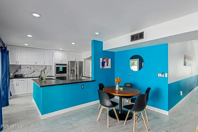 a kitchen with stainless steel appliances kitchen island granite countertop a sink and a refrigerator