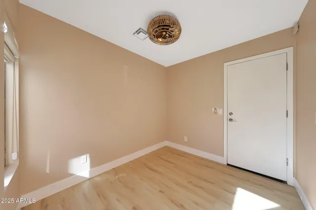 a view of a hallway with wooden floor and a kitchen