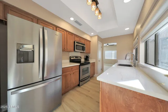 a kitchen with stainless steel appliances granite countertop a sink stove and refrigerator