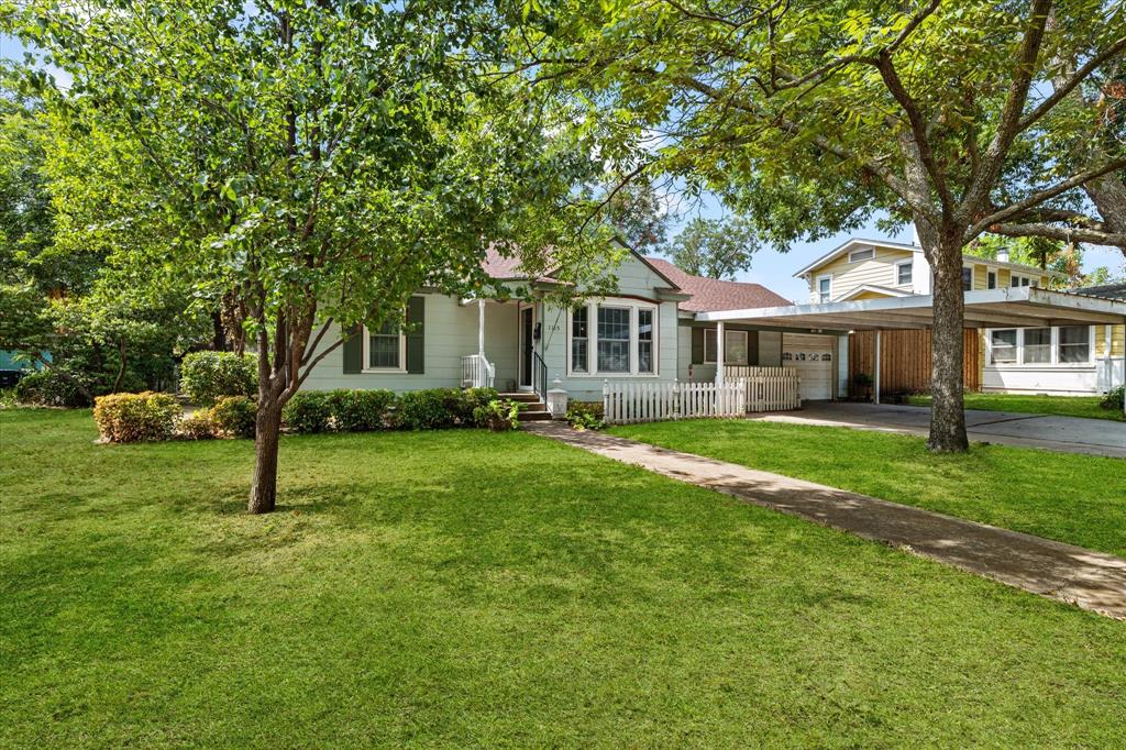 View of front facade featuring an attached carport, driveway, and roof with shingles