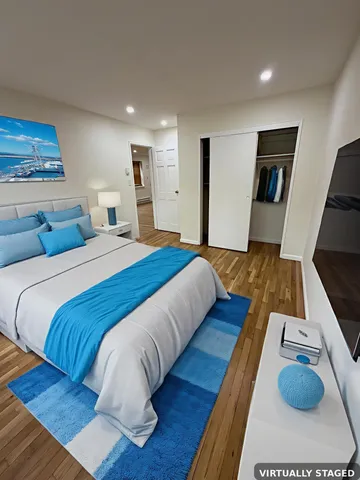 a bed sitting in a bedroom and view of living room