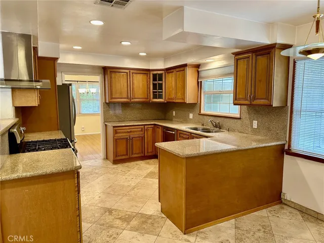 a kitchen with kitchen island granite countertop a sink stove and refrigerator