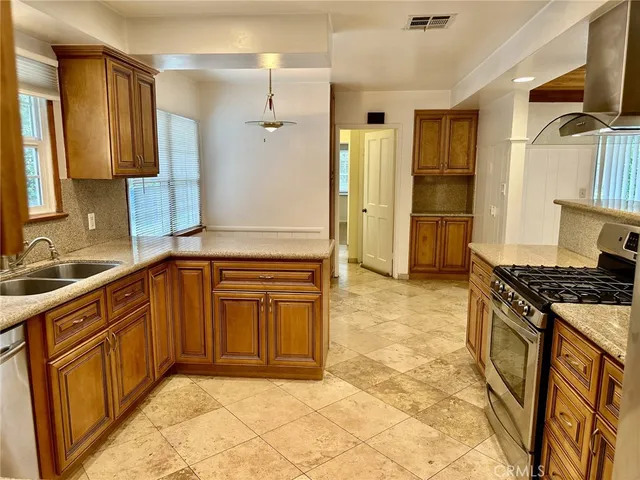 a kitchen with granite countertop a sink stove and refrigerator
