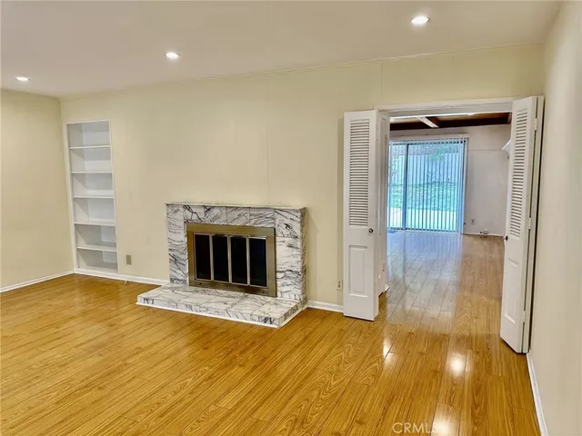a view of a livingroom with wooden floor and a fireplace