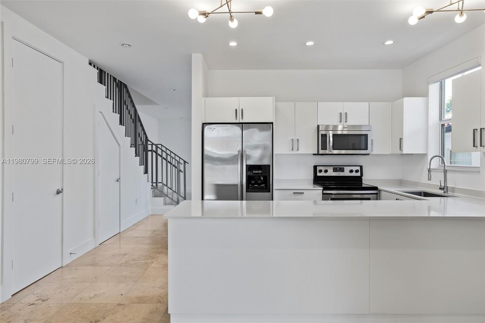 2786 Southwest 34th Avenue Miami, FL 33133 - Photo 11 of 42 a kitchen with stainless steel appliances a refrigerator a stove a sink a microwave and cabinets