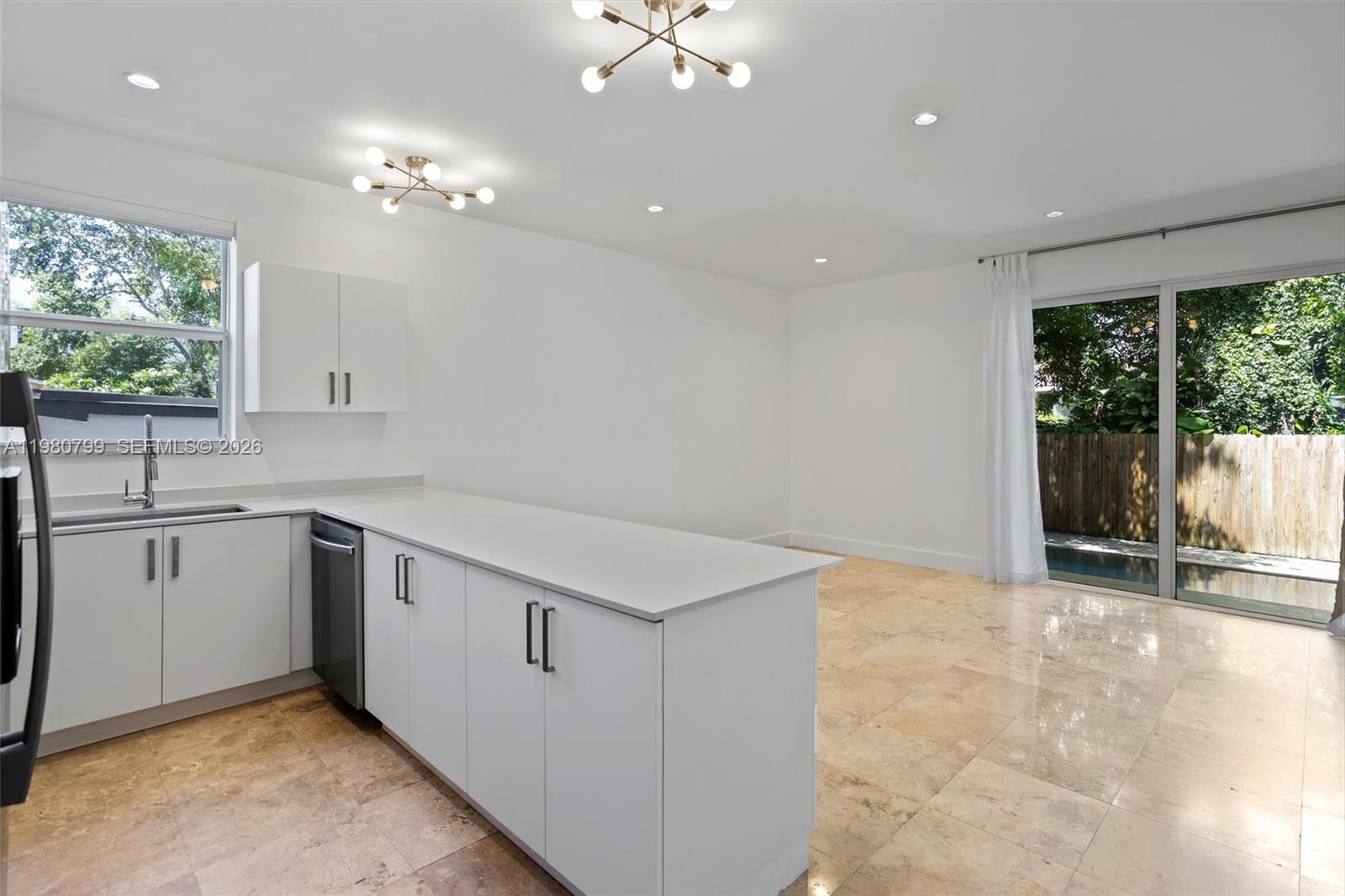 2786 Southwest 34th Avenue Miami, FL 33133 - Photo 13 of 42 a kitchen with a sink cabinets and chandelier