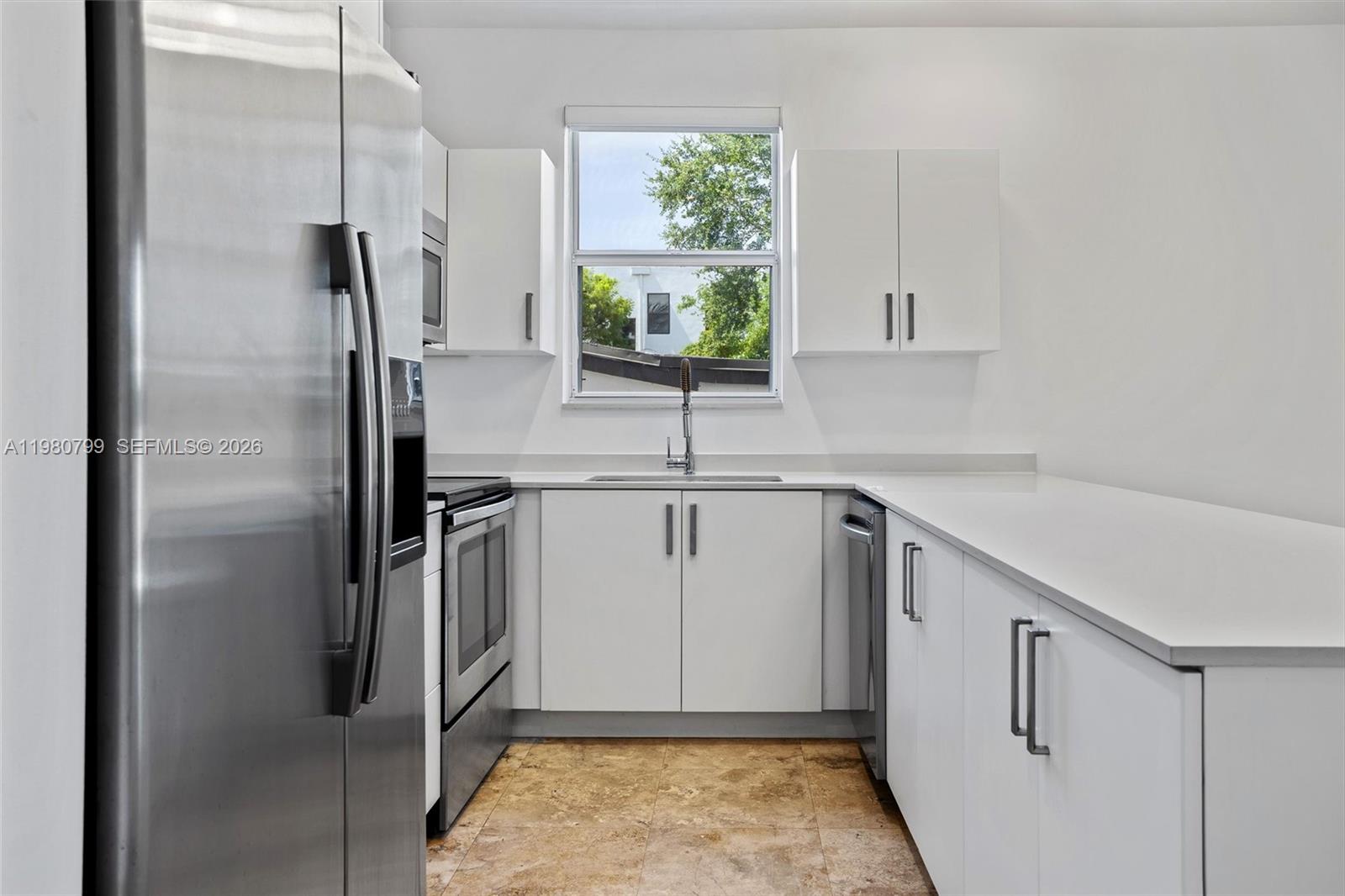 2786 Southwest 34th Avenue Miami, FL 33133 - Photo 10 of 42 a kitchen with white cabinets and stainless steel appliances