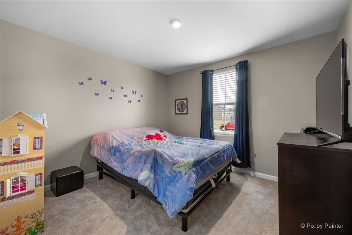 205 North Buckeye Street Waterman, IL 60556 - Photo 14 of 34 a bedroom with a bed and a flat tv screen on dresser