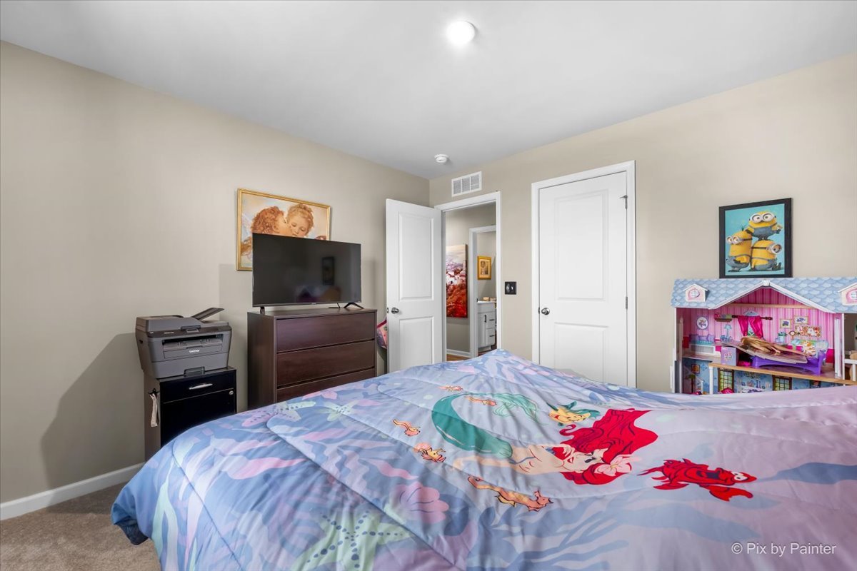 205 North Buckeye Street Waterman, IL 60556 - Photo 15 of 34 a bedroom with a bed and a flat screen tv