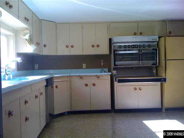 15110 Kivett Lane Reno, NV 89521 - Photo 6 of 9 a kitchen with granite countertop white cabinets and white appliances