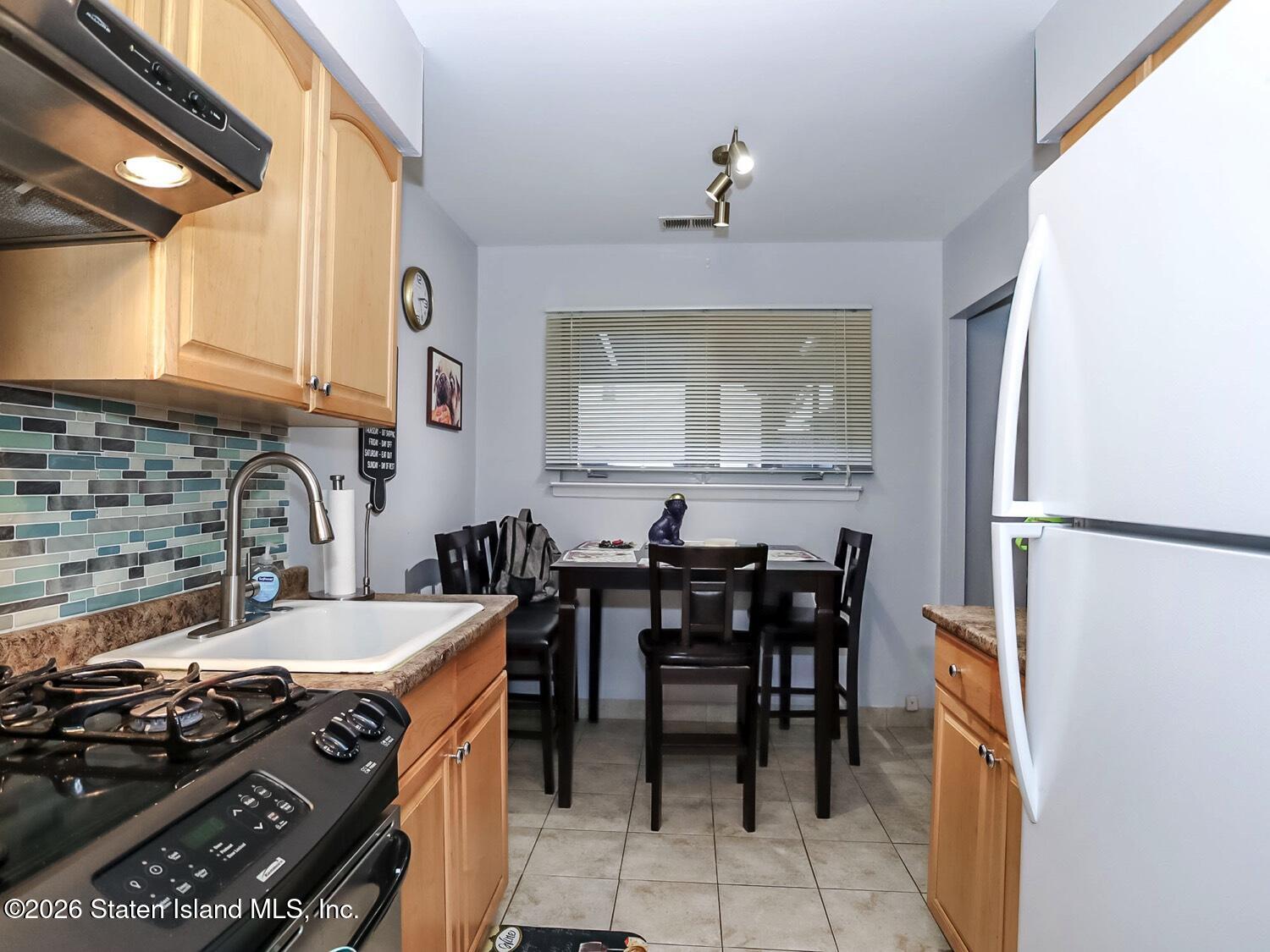 11 Firth Road Staten Island, NY 10314 - Photo 19 of 34 a kitchen with a stove and chairs