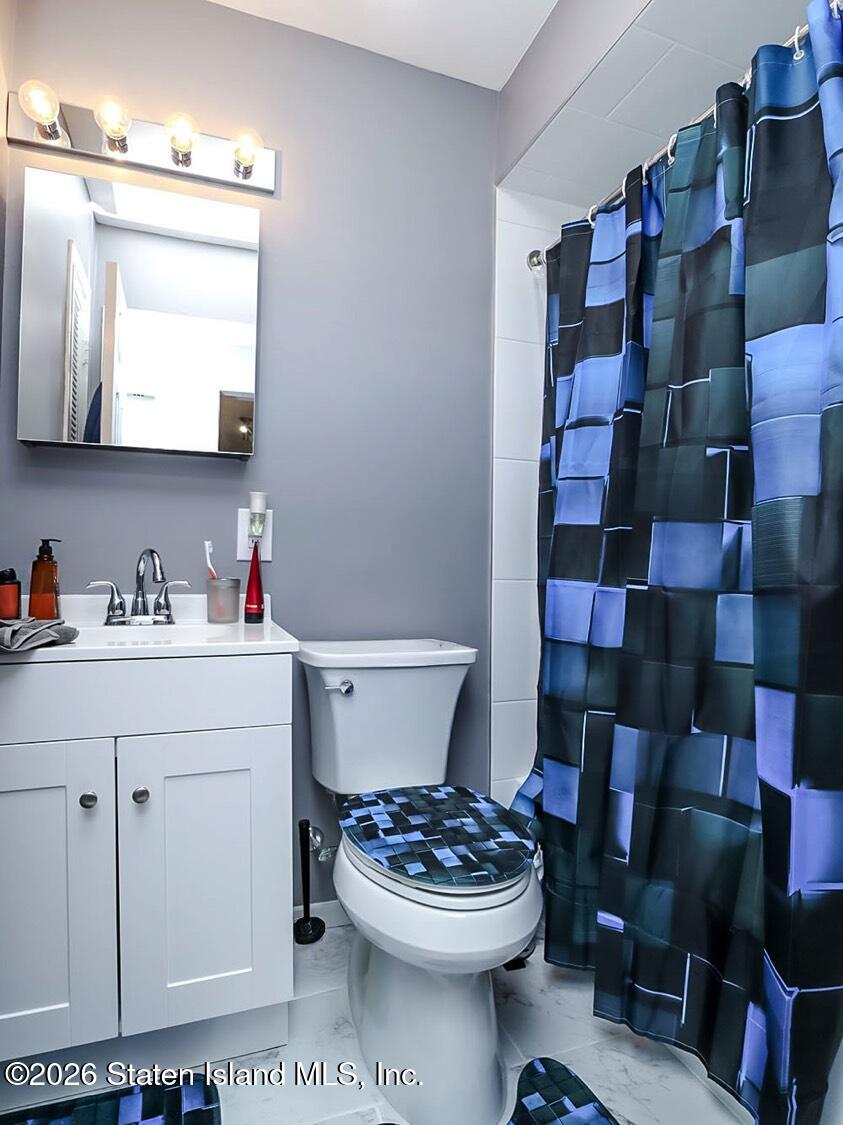 11 Firth Road Staten Island, NY 10314 - Photo 21 of 34 a bathroom with a sink a toilet and a mirror