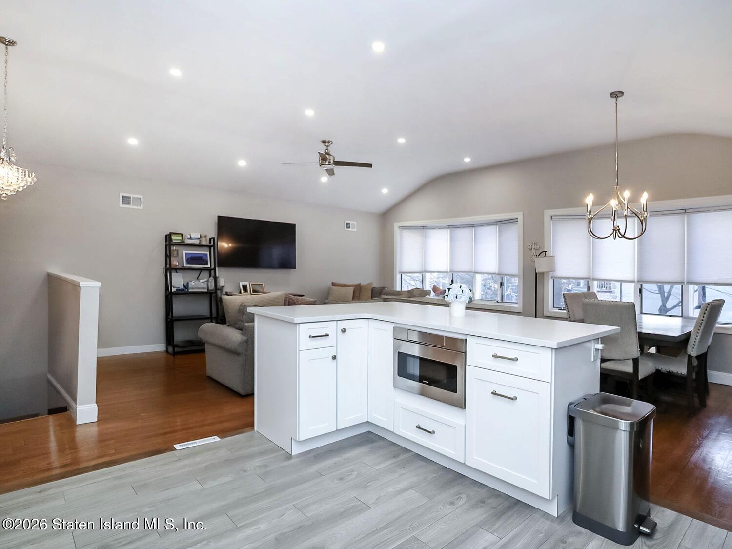 11 Firth Road Staten Island, NY 10314 - Photo 8 of 34 a open kitchen with stainless steel appliances kitchen island granite countertop a stove top oven a sink dishwasher a dining table and chairs with wooden floor