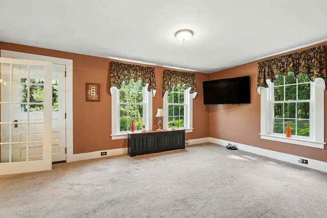 an empty room with windows flat screen tv and windows