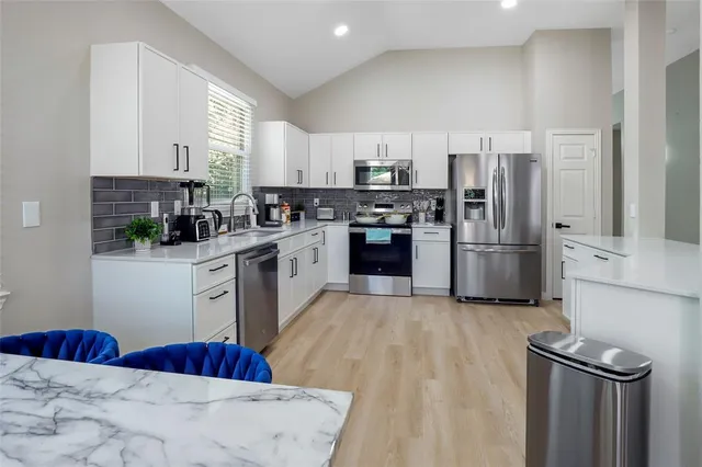 a kitchen with stainless steel appliances granite countertop a refrigerator sink and stove