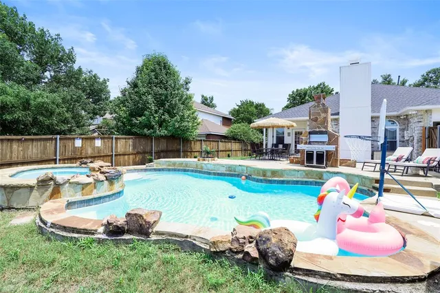 a view of a swimming pool with a lounge chairs and a big yard