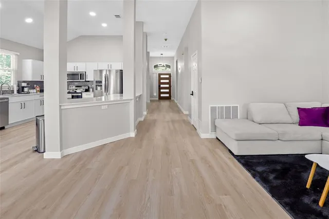 a view of a living room and kitchen with furniture wooden floor and window