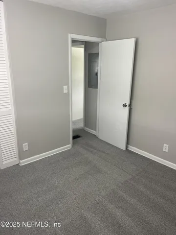 an empty room with closet and mirror