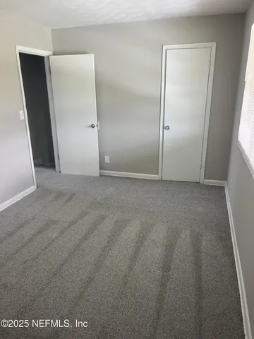 an empty room with mirror and entrance
