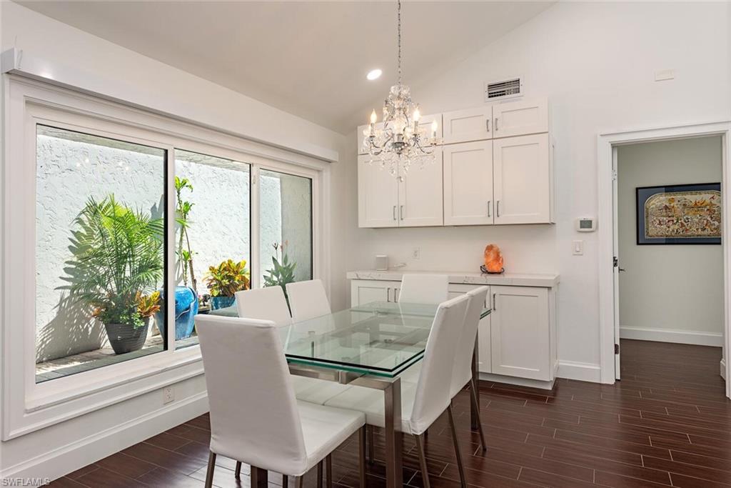 748 Reef Point Circle Naples, FL 34108 - Photo 10 of 23 Dining space with wood tiled floors, vaulted ceiling, a chandelier, and recessed lighting