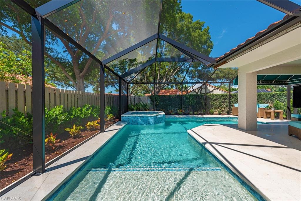 748 Reef Point Circle Naples, FL 34108 - Photo 2 of 23 View of pool with a lanai, a sunroom, a pool with connected hot tub, and a patio area