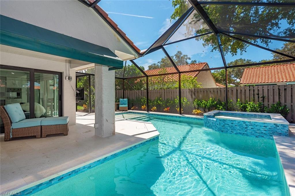 748 Reef Point Circle Naples, FL 34108 - Photo 19 of 23 View of swimming pool featuring a lanai, a patio, a pool with connected hot tub, and a sunroom