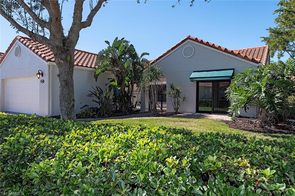 748 Reef Point Circle Naples, FL 34108 - Photo 3 of 23 Mediterranean / spanish house featuring a tiled roof, stucco siding, and a garage