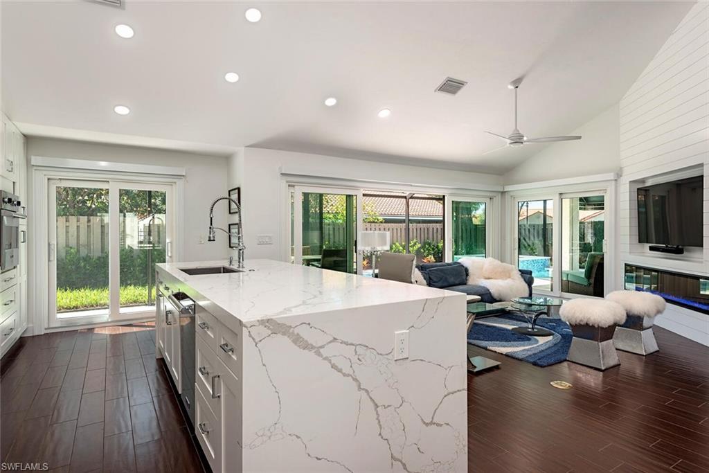 748 Reef Point Circle Naples, FL 34108 - Photo 22 of 23 Kitchen featuring white cabinetry, light stone counters, recessed lighting, open floor plan, and dark wood-style flooring