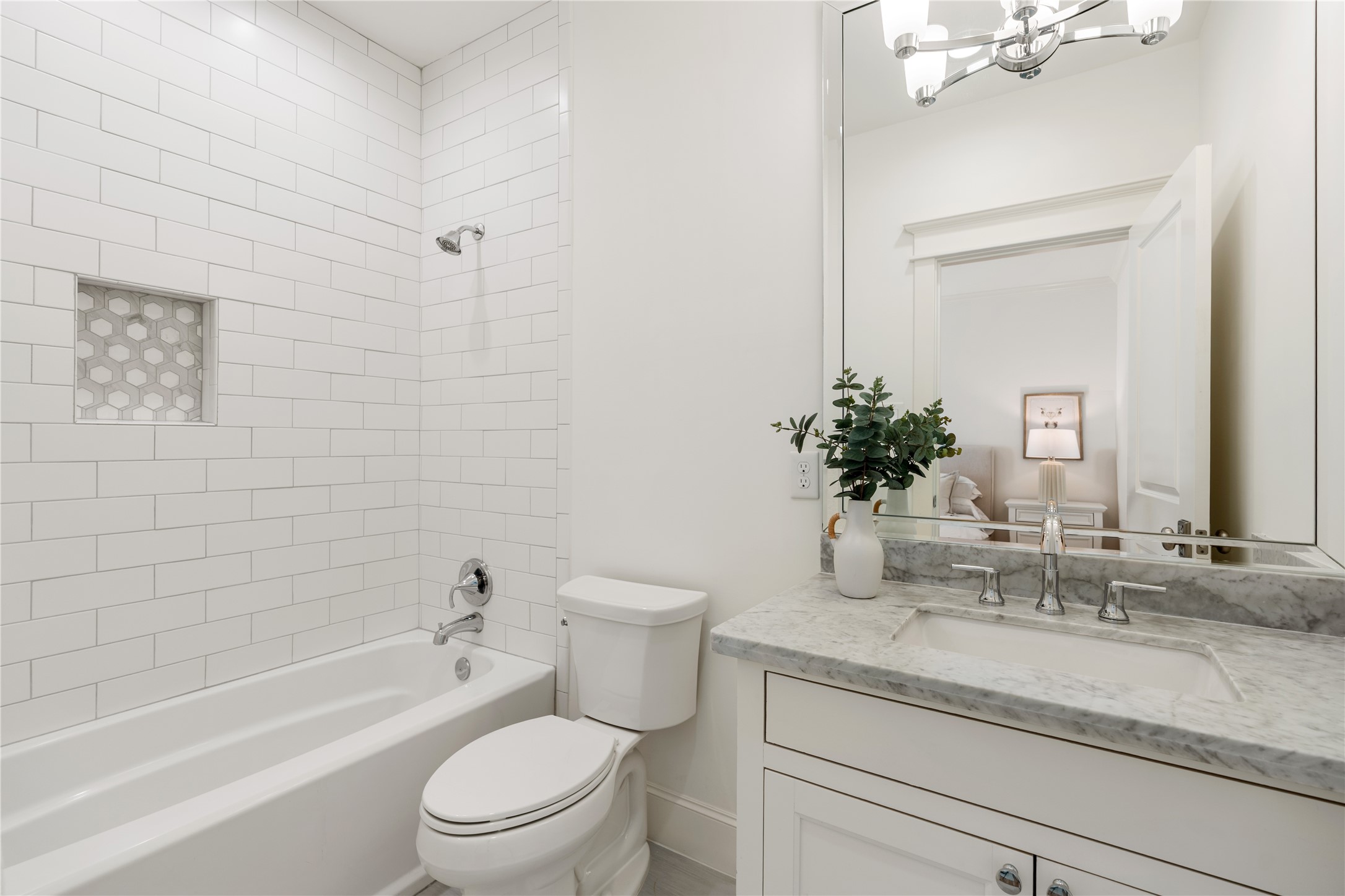 925 Tulane Street, Unit A Houston, TX 77008 - Photo 31 of 49 This en suite secondary bathroom includes a large tub shower, beautiful tilework, a marble vanity and chrome hardware.