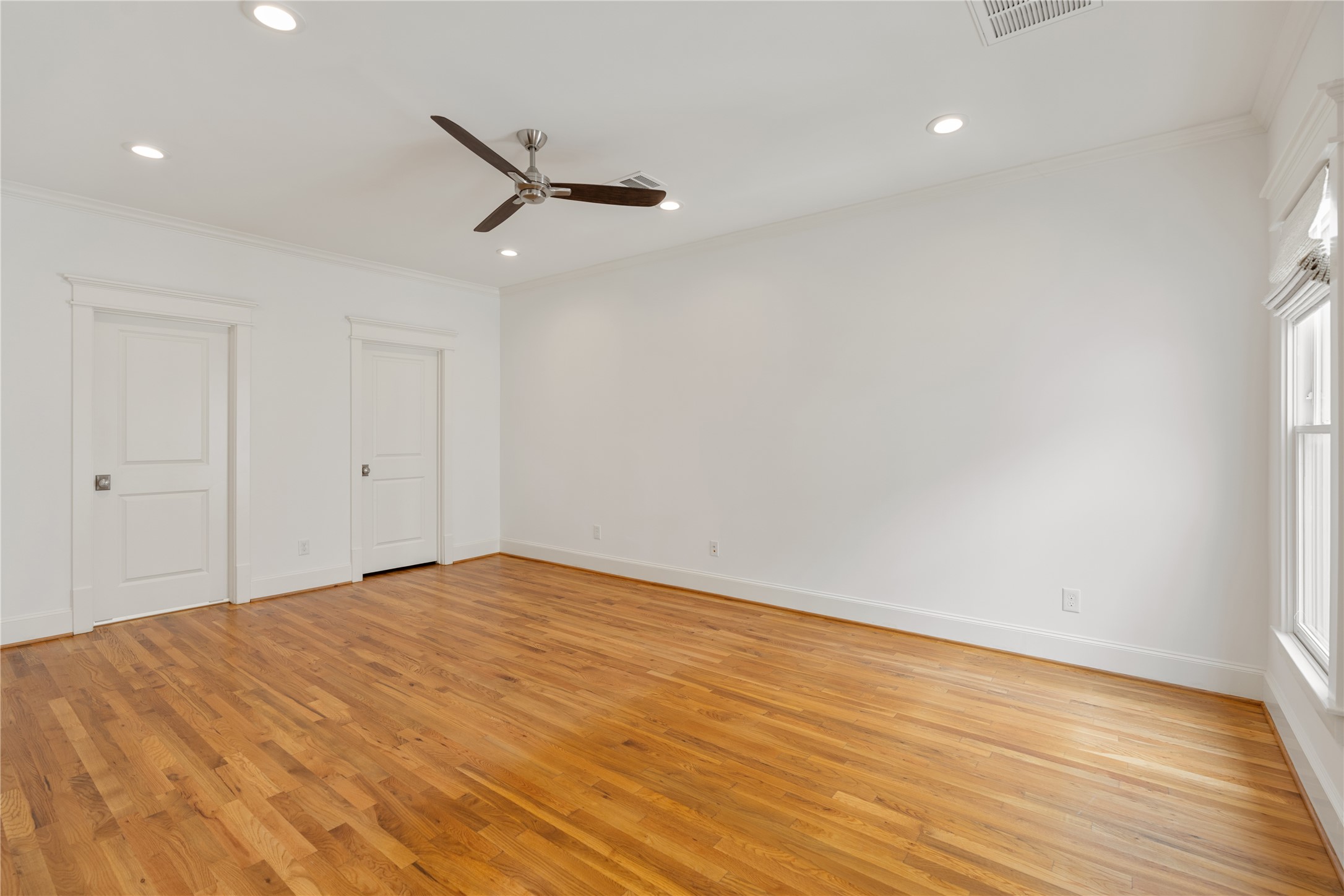 925 Tulane Street, Unit A Houston, TX 77008 - Photo 34 of 49 Positioned at the rear of the second level, this expansive secondary suite boasts abundant natural light, a ceiling fan and a large walk-in closet.