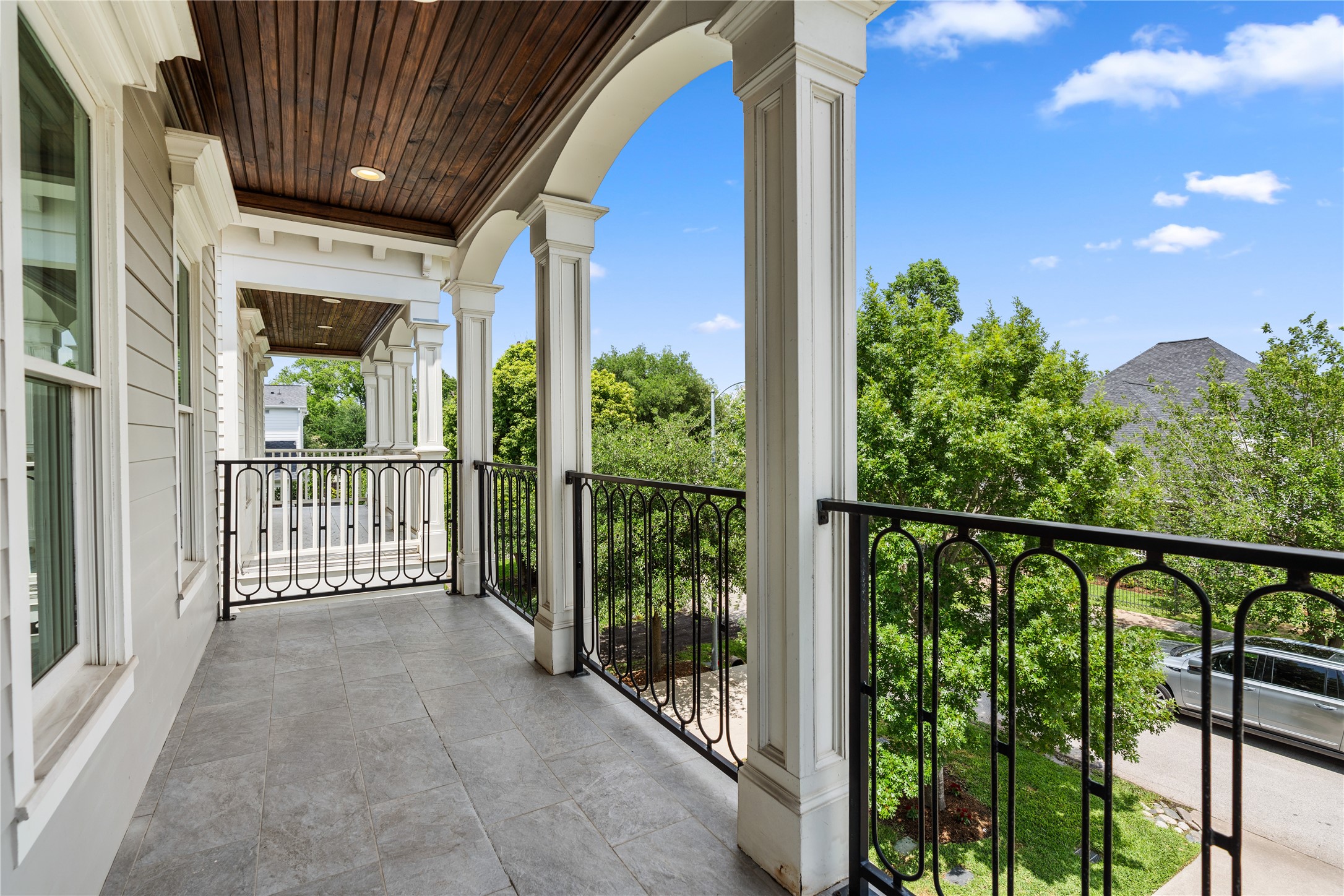 925 Tulane Street, Unit A Houston, TX 77008 - Photo 37 of 49 The primary bedroom opens to a lovely covered balcony with a beadboard ceiling, custom ironwork and treetop views.